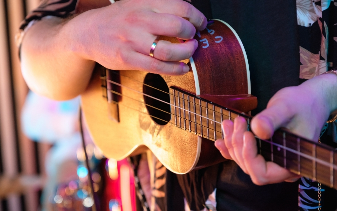 Intro to Ukulele - An close up photo of a musician's hands playing a Ukulele.