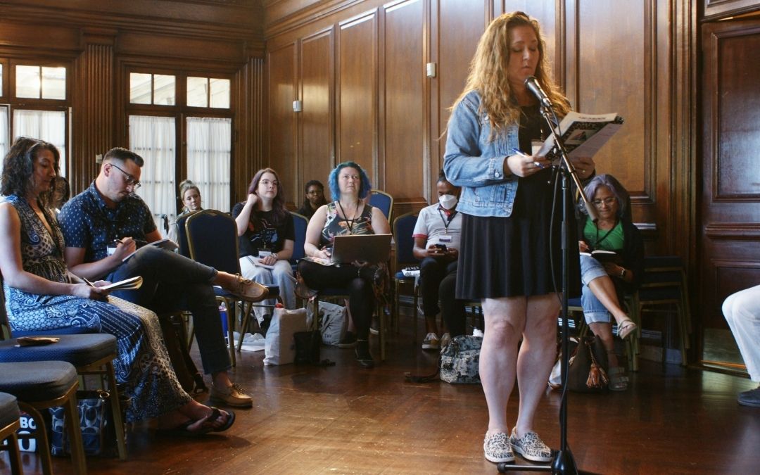 Poetry Circle - Photo of participants listening to a community member perform what they have written.