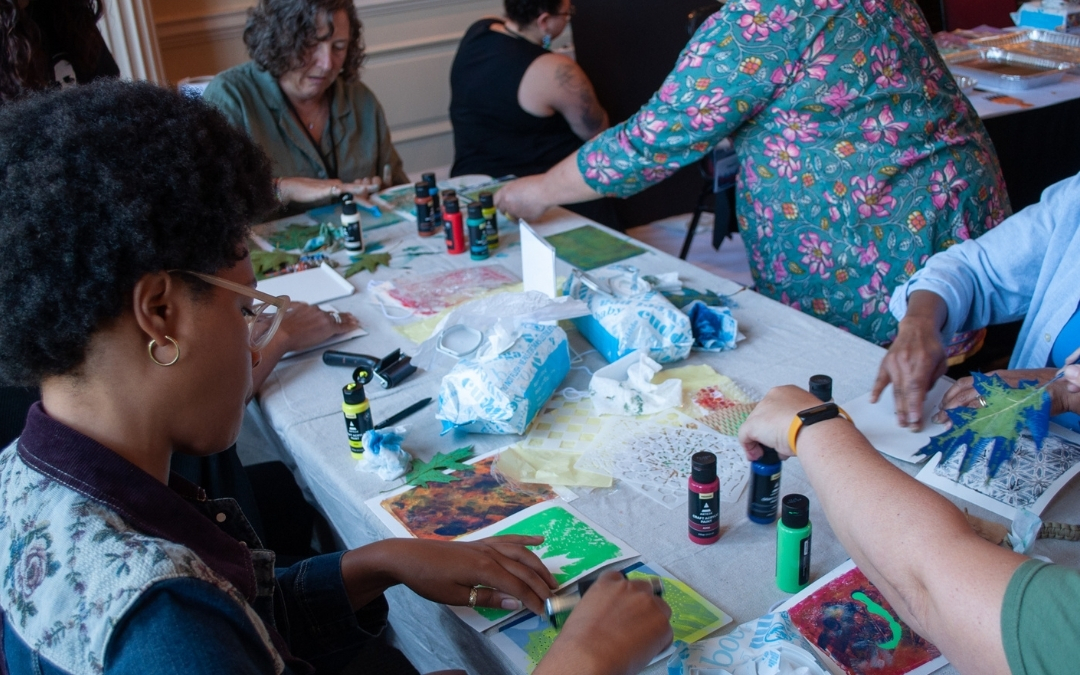 The Visual Art Experience - Participants from 2024's Day of Belonging are painting landscape scenery outdoors under the instruction of Veteran Artist Shaun Smith.